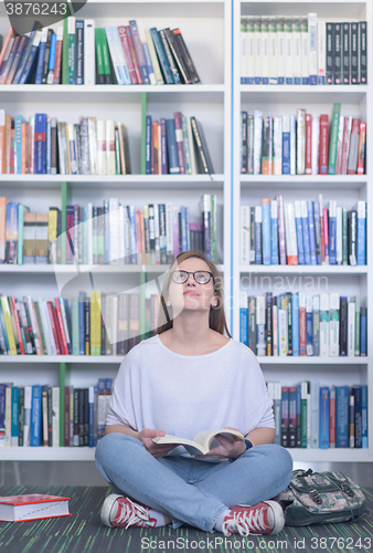 Image of famale student reading book in library