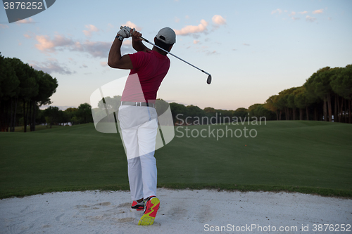 Image of golfer hitting a sand bunker shot on sunset