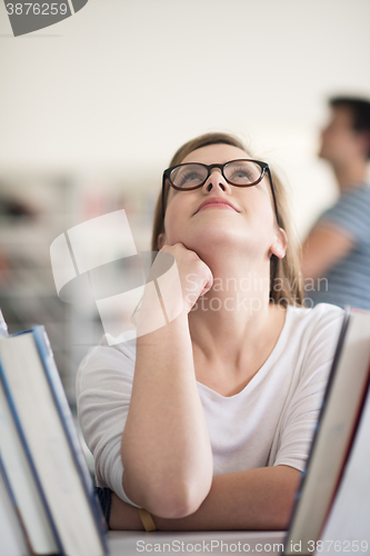 Image of portrait of famale student selecting book to read in library