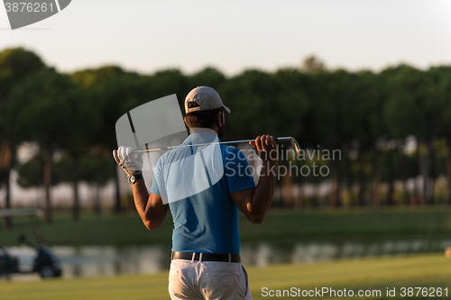 Image of golfer from back at course looking to hole in distance