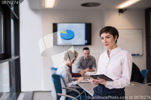 Image of hispanic businesswoman with tablet at meeting room