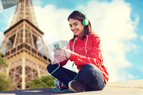 Image of happy young woman with smartphone and headphones