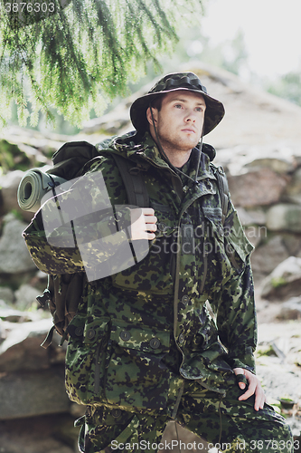 Image of young soldier with backpack in forest