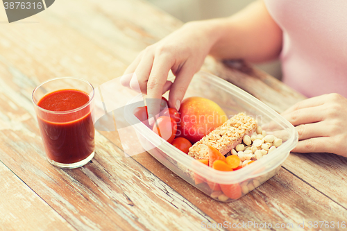 Image of close up of woman with vegetarian food in box