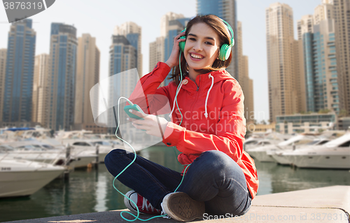 Image of happy young woman with smartphone and headphones