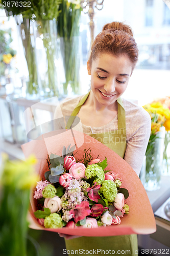 Image of smiling florist woman with bunch at flower shop