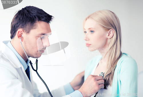 Image of doctor with stethoscope listening to the patient