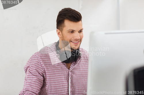 Image of creative man with headphones and computer