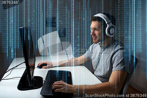 Image of man in headset playing computer video game at home