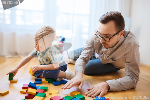 Image of father and son playing with toy blocks at home