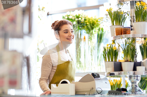 Image of smiling florist woman at flower shop cashbox