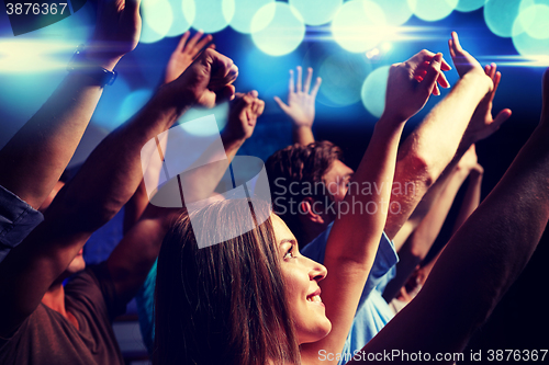 Image of smiling friends at concert in club