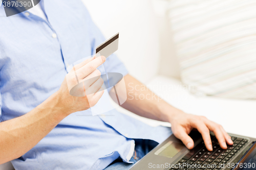 Image of close up of man with laptop and credit card