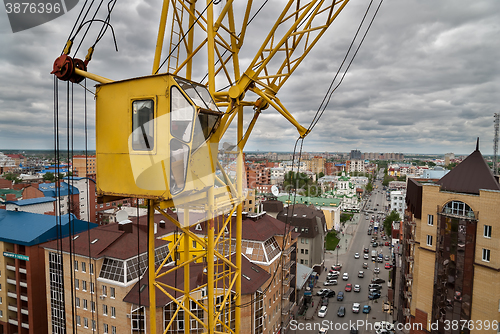 Image of Construction crane over street traffic background