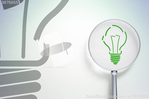 Image of Finance concept:  Light Bulb with optical glass on digital background