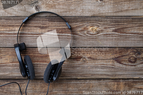 Image of Headphones over wooden table.