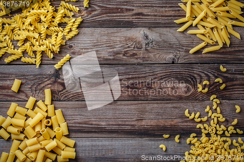 Image of Mixed dried pasta selection on wooden background.