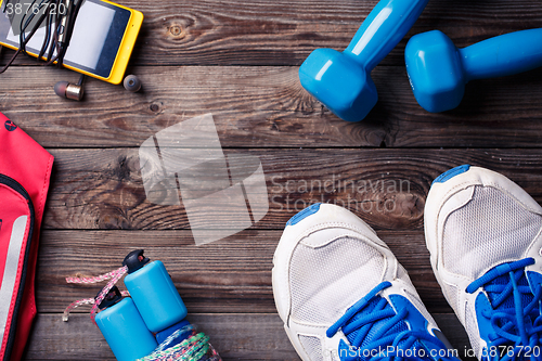 Image of Sports equipment - sneakers, skipping rope, dumbbells, smartphone and headphones. 