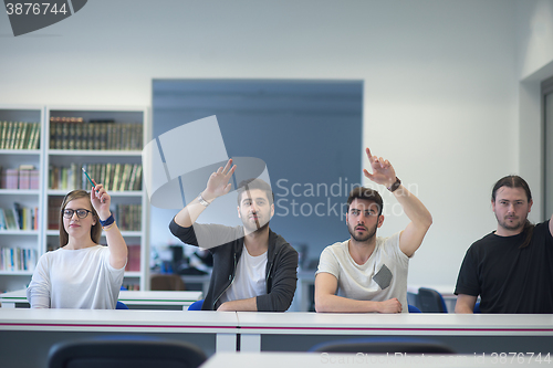 Image of group of students  raise hands up