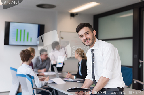 Image of young business man with tablet at office meeting room