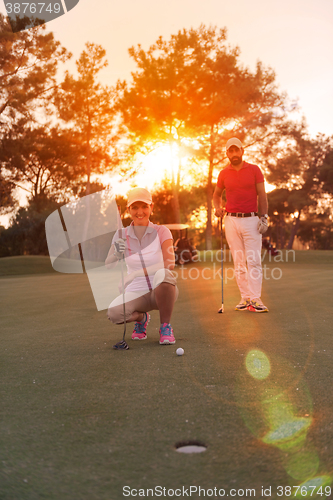 Image of couple on golf course at sunset