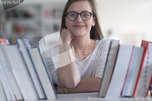 Image of portrait of famale student selecting book to read in library