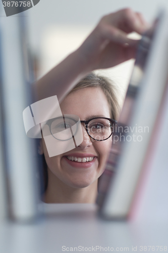 Image of portrait of famale student selecting book to read in library