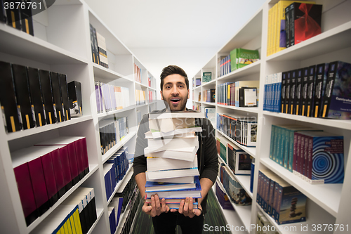 Image of Student holding lot of books in school library