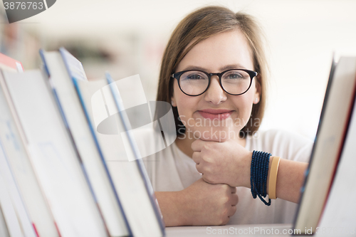 Image of portrait of famale student selecting book to read in library