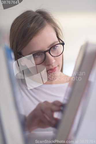 Image of portrait of famale student selecting book to read in library