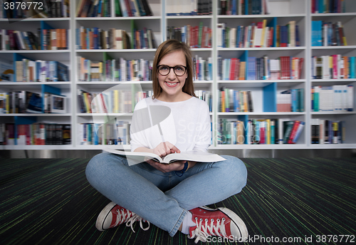 Image of female student study in library, using tablet and searching for 