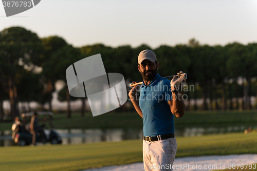 Image of golfer  portrait at golf course on sunset