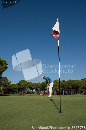 Image of golf player hitting shot at sunny day