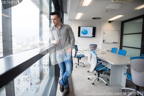 Image of young business man using smart phone at office