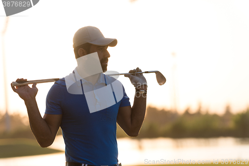 Image of golfer  portrait at golf course on sunset