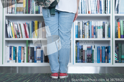 Image of famale student selecting book to read in library