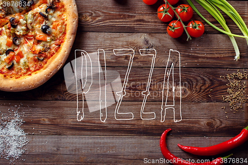 Image of Italian pizza with tomatoes on a wooden table, top view, close-up