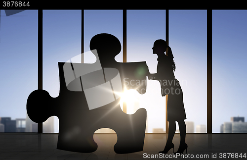 Image of silhouette of woman mowing puzzle over office