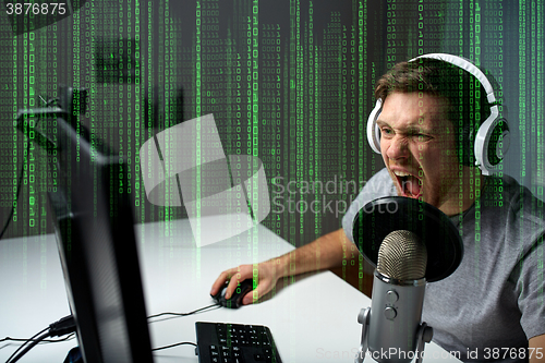 Image of man in headset playing computer video game at home