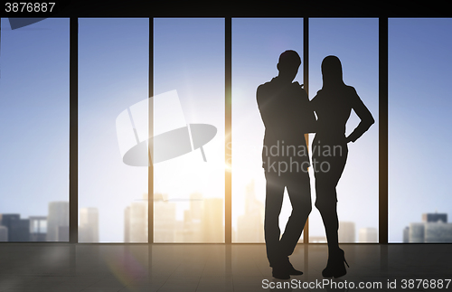 Image of silhouettes of business partners over office