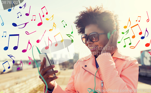 Image of happy young woman with smartphone and headphones