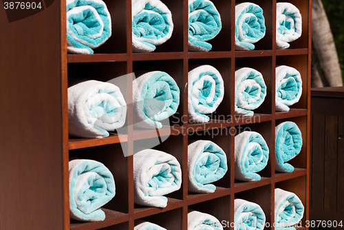 Image of close up of shelf with rolled bath towels