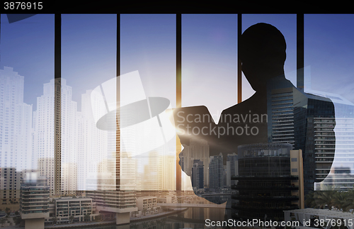 Image of silhouette of businessman with tablet pc at office