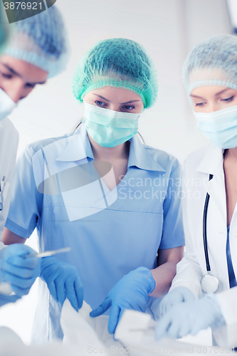 Image of young group of doctors doing operation