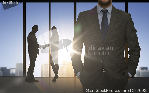 Image of business partners silhouettes shaking hands