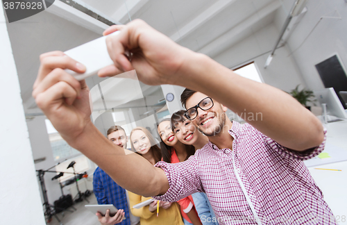 Image of creative business team taking selfie at office