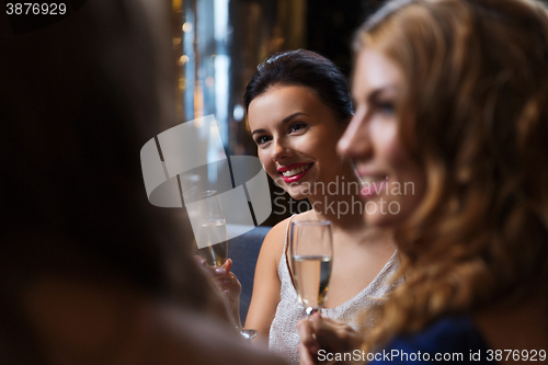 Image of happy women with champagne glasses at night club