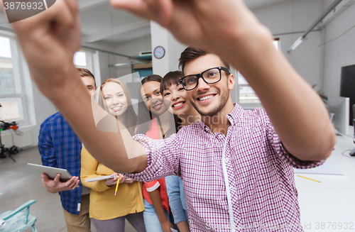Image of creative business team taking selfie at office
