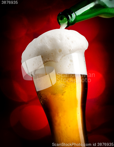 Image of Pouring beer on red background