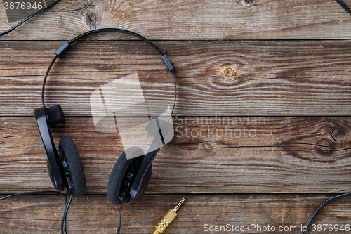 Image of Headphones over wooden table.
